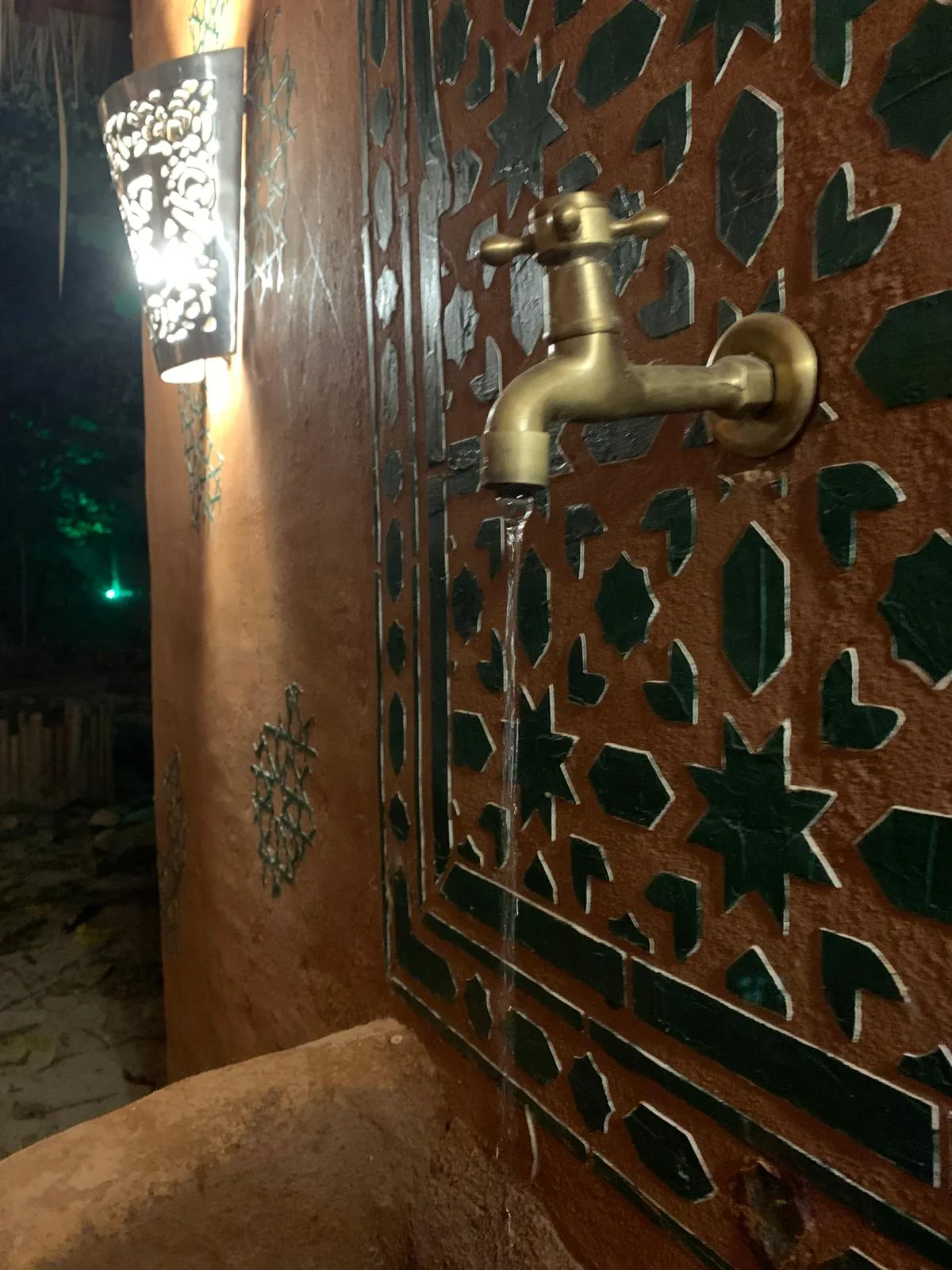 Brass tap on a green zellige mosaic fountain at Dar Mansour